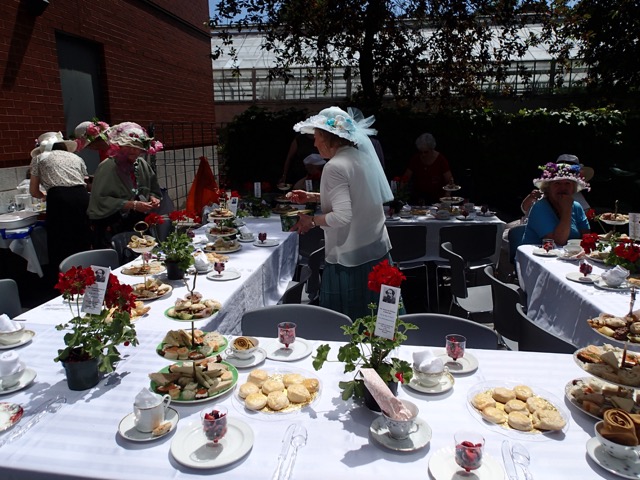 Buttery scones are served with individual servings of cream and jam.